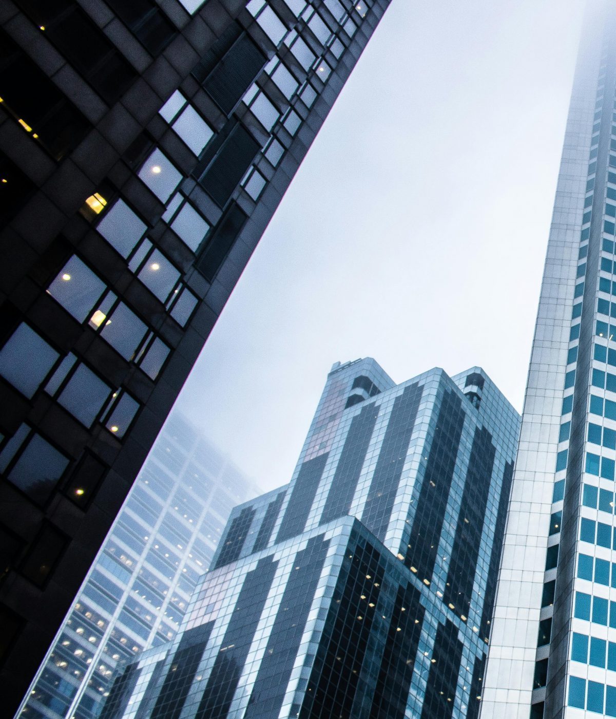 Dramatic view of modern skyscrapers shrouded in fog in an urban cityscape.