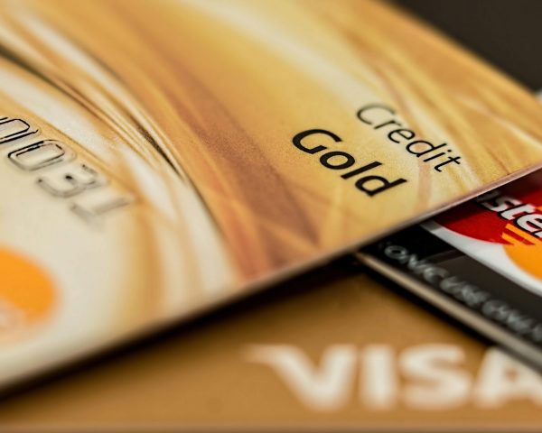 Stack of various branded credit cards focusing on gold card showing finance and cashless concept.